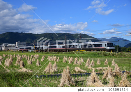 Odakyu Romance Car running through a rice field after harvesting 108691814