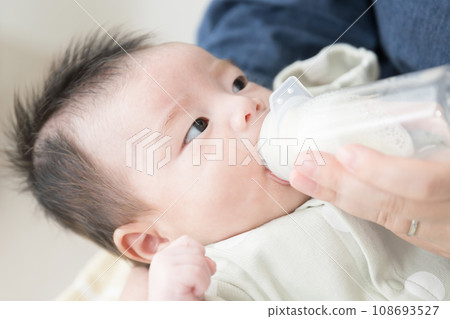 Baby drinking milk from a bottle Baby drinking milk from a bottle 108693527