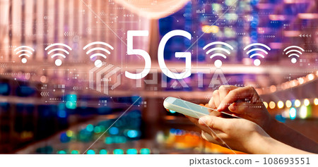 5G network with person using a smartphone in city at night 5G network with person using a smartphone in city at night 108693551