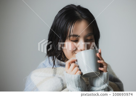 A woman drinking a hot drink A woman drinking a hot drink 108693974