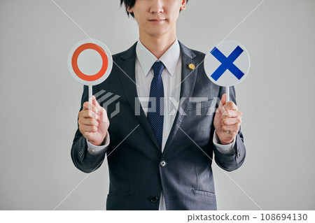 A male lawyer deciding whether it is legal or illegal against a white background 108694130