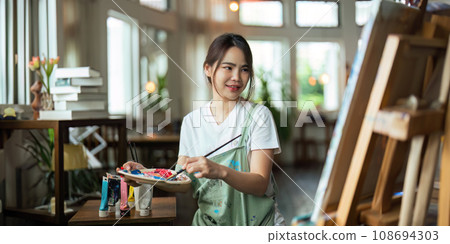 hand of artist with brush painting picture art, creativity, artistic and artwork, painting, Colorful artist brushes and paint palette concept 108694303