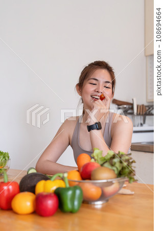 Young Asian healthy beautiful woman with casual clothes is smile and slicing cut tomatoes to eat fruit to diet at home in kitchen in holiday Young Asian healthy beautiful woman with casual clothes is smile and slicing cut tomatoes to eat fruit to diet at home in kitchen in holiday 108694664