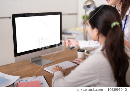 Computer mock up. Two business people discussion in office with visible white empty screen with copy space Computer mock up. Two business people discussion in office with visible white empty screen with copy space 108694940