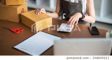 Entrepreneur of freelance Asian woman using laptop and calculator to receive and review order online to prepare to pack sell to customers, online small business ideas Entrepreneur of freelance Asian woman using laptop and calculator to receive and review order online to prepare to pack sell to customers, online small business ideas 108695021