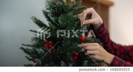 Woman decorate the christmas tree. Christmas atmosphere at cozy home interior 108695055