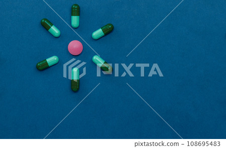 Pharmaceutical tablets, pills and capsules are arranged in the form of a flower with petals. Top view, flat lay and copy space. Pharmaceutical tablets, pills and capsules are arranged in the form of a flower with petals. Top view, flat lay and copy space. 108695483