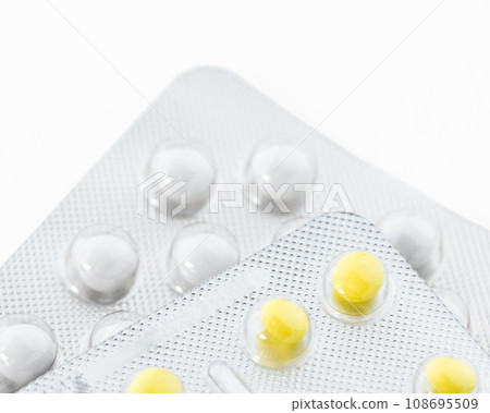 Yellow and white pills in plastic package, copy space. Healthcare and health insurance concept. Yellow and white pills in plastic package, copy space. Healthcare and health insurance concept. 108695509