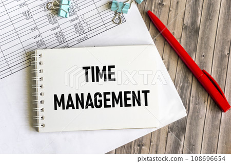Time Management text on notepad and wooden table with reports and red pen. Business concept. Time Management text on notepad and wooden table with reports and red pen. Business concept. 108696654