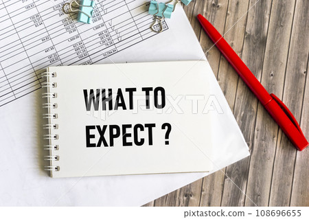 On the table there is a pen, charts and a notepad with the inscription - WHAT TO EXPECT. On the table there is a pen, charts and a notepad with the inscription - WHAT TO EXPECT. 108696655