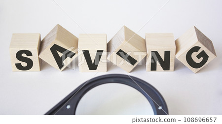 The concept of saving money for accounting finance with a magnifying glass on a white background. The concept of saving money for accounting finance with a magnifying glass on a white background. 108696657