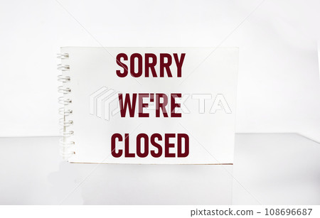 Closed business or store concept. Red letters on a notepad. Sorry we are closed on white background 108696687