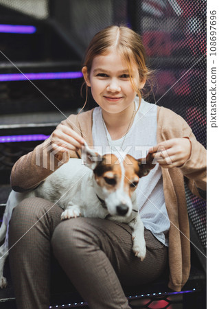 Cute teenage blonde girl with dog on the steps. Cute teenage blonde girl with dog on the steps. 108697696