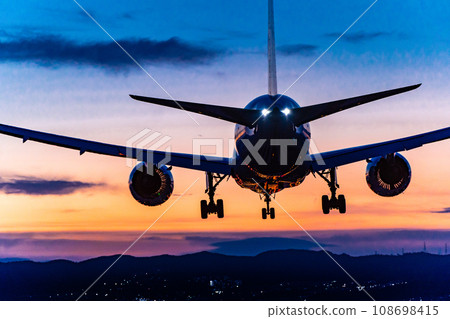 Jet airliner landing in the sunset 108698415