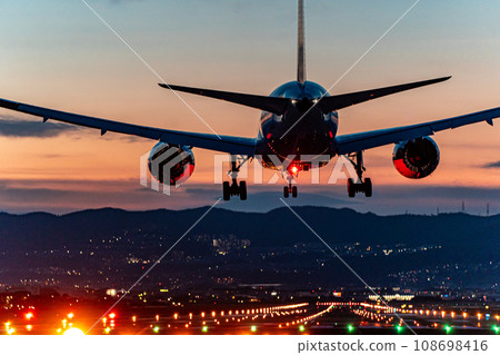 Passenger plane landing at Itami Airport during sunset 108698416