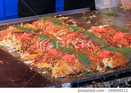 Okonomiyaki from food stalls on festival days Okonomiyaki with plenty of eggs and vegetables Okonomiyaki from food stalls on festival days Okonomiyaki with plenty of eggs and vegetables 108698511
