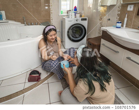 Asian laughing beauties begin their morning routine with acne treatment and facial massage in the bathroom Asian laughing beauties begin their morning routine with acne treatment and facial massage in the bathroom 108701576