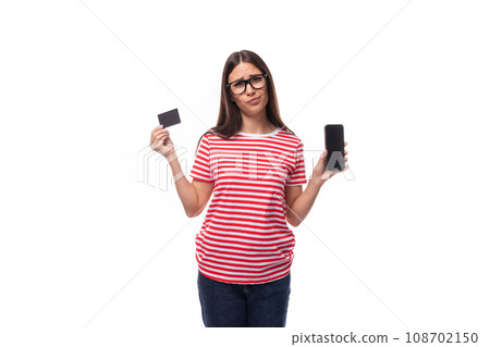 pretty 35 year old european lady in a red striped t-shirt and glasses demonstrates a plastic credit pretty 35 year old european lady in a red striped t-shirt and glasses demonstrates a plastic credit 108702150