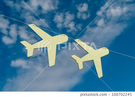Airplanes hanging on string, rope in blue sky with clouds. Air planes decor 108702245
