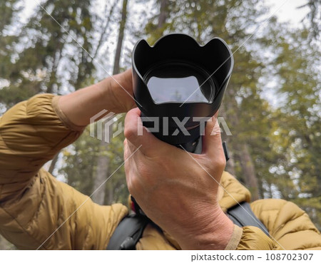 Photographer taking photo in nature, holding digital camera. Cameraman Photographer taking photo in nature, holding digital camera. Cameraman 108702307
