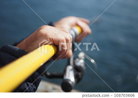 Fisherman with rod, spinning reel , 108703606