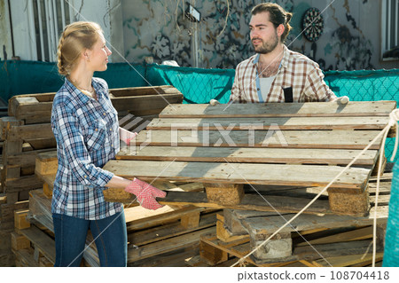 Couple working with wooden pallets 108704418
