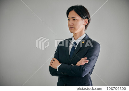 A male lawyer with his arms folded against a white background A male lawyer with his arms folded against a white background 108704800