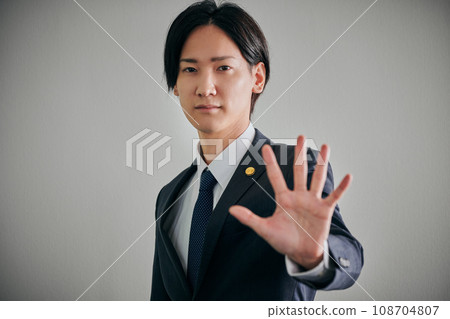 A male lawyer who holds his palm forward A male lawyer who holds his palm forward 108704807