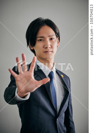 A male lawyer who holds his palm forward A male lawyer who holds his palm forward 108704813