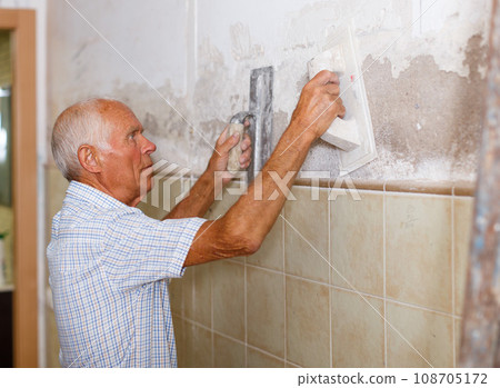 Elderly man with spatula and plaster Elderly man with spatula and plaster 108705172