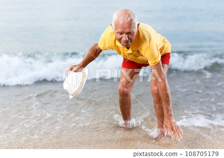 Elderly man touches the water temperature 108705179