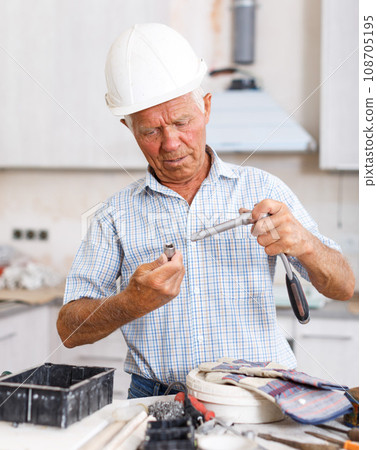 Man in hardhat engaged in renovation work 108705195