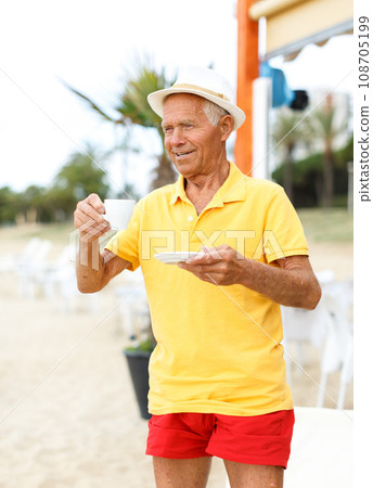Mature nice man standing with cup of drink 108705199