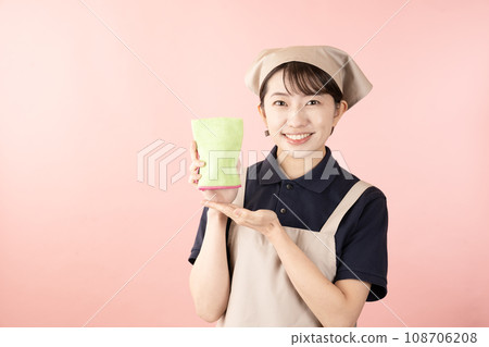 Female house cleaning worker with towel in pink background 108706208