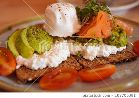Cottage cheese, avocado, smoked salmon crackers and poached egg topping Cottage cheese, avocado, smoked salmon crackers and poached egg topping 108706391
