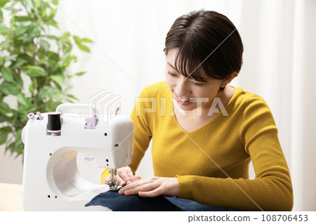 A woman sewing machine A woman sewing machine 108706453
