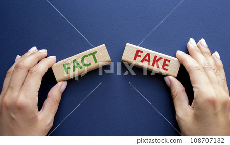 Fact or Fake symbol. Concept word Fact or Fake on wooden blocks. Businessman hand. Beautiful deep blue background. Business and Fact or Fake concept. Copy space 108707182