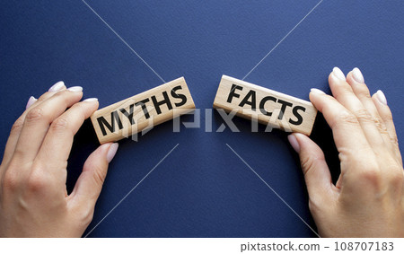 Facts or Myths symbol. Concept word Facts or Myths on wooden blocks. Businessman hand. Beautiful deep blue background. Business and Facts or Myths concept. Copy space 108707183