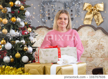 Woman with a gift in a Christmas interior 108707606