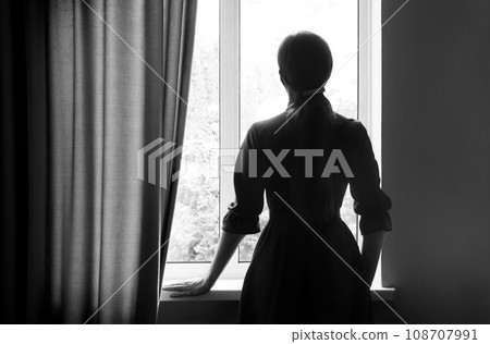 Praying woman at the window 108707991