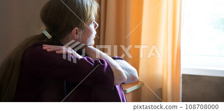 Sad girl sitting by the window Sad girl sitting by the window 108708000