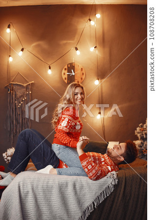People in a Christman decorations. Man and woman in a red sweater. Family at home. People in a Christman decorations. Man and woman in a red sweater. Family at home. 108708208
