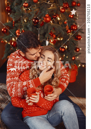 People in a Christman decorations. Man and woman in a red sweater. Family at home. People in a Christman decorations. Man and woman in a red sweater. Family at home. 108708218