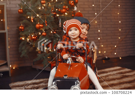 Cute little boy in a red sweater. Children by the christmas tree. 108708224