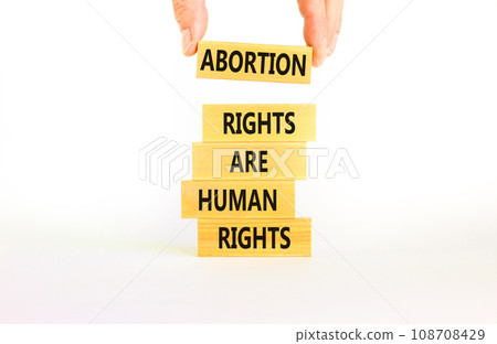 Abortion rights symbol. Concept words Abortion rights are human rights on wooden blocks. Businessman hand. Beautiful white background. Business medical abortion rights concept. Copy space. Abortion rights symbol. Concept words Abortion rights are human rights on wooden blocks. Businessman hand. Beautiful white background. Business medical abortion rights concept. Copy space. 108708429