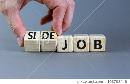 Side job symbol. Businessman turns wooden cubes and changes concept words Job to Side job. Beautiful grey table grey background, copy space. Business side job concept. Side job symbol. Businessman turns wooden cubes and changes concept words Job to Side job. Beautiful grey table grey background, copy space. Business side job concept. 108708446