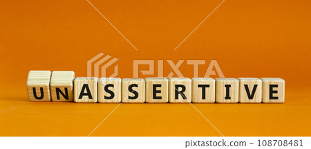 Assertive or unassertive symbol. Turned wooden cubes and changed concept words Unassertive to Assertive. Beautiful orange background. Business and assertive or unassertive concept. Copy space. Assertive or unassertive symbol. Turned wooden cubes and changed concept words Unassertive to Assertive. Beautiful orange background. Business and assertive or unassertive concept. Copy space. 108708481