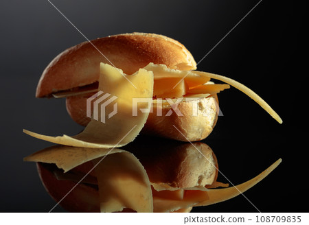 Sandwich with Parmesan cheese on a black background. 108709835