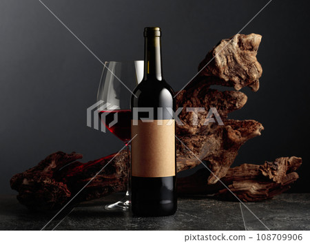 Bottle and glass of red wine with old empty label. Bottle and glass of red wine with old empty label. 108709906
