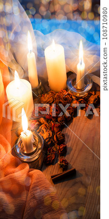 Candles and dried rosebuds on the table Candles and dried rosebuds on the table 108710980